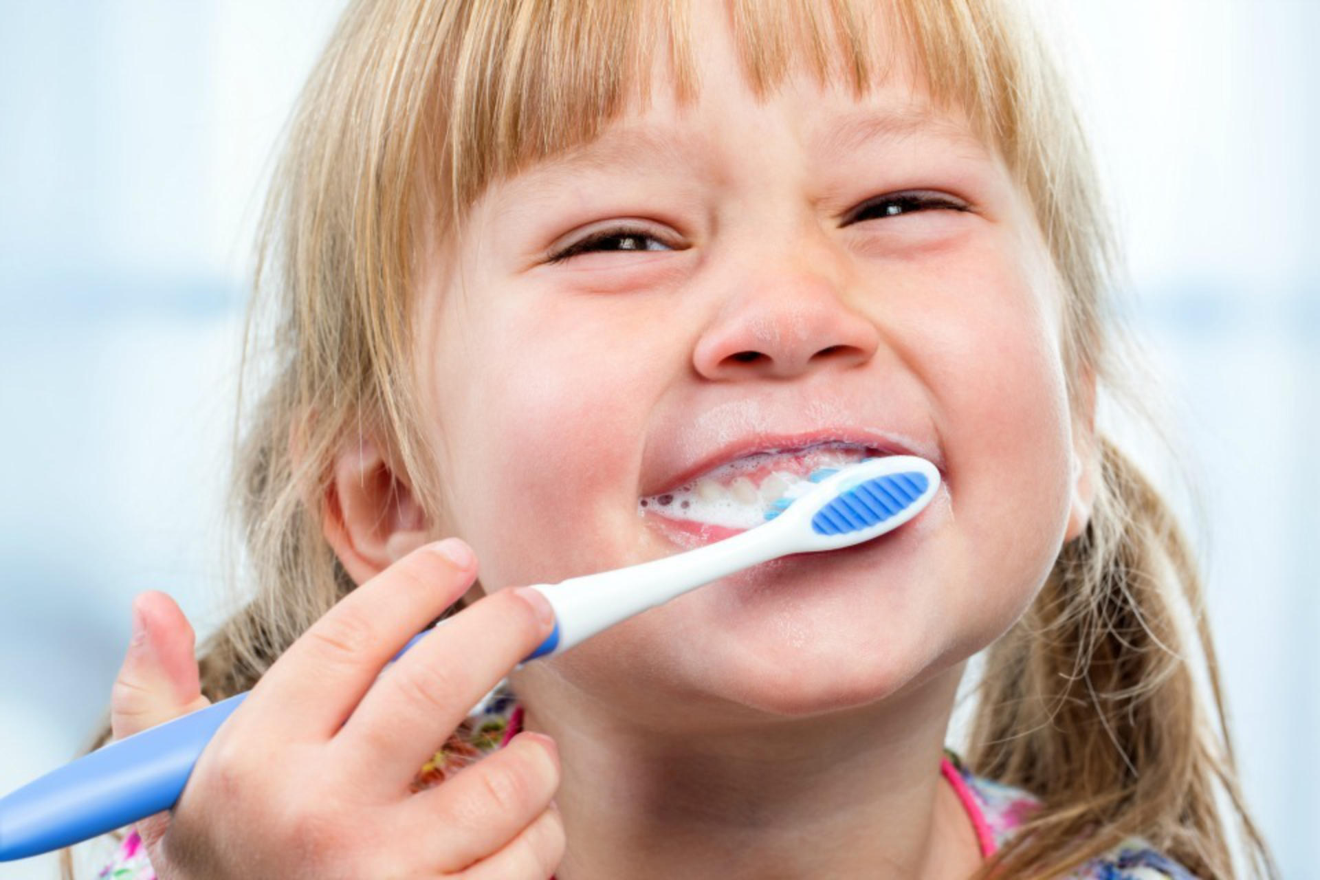 Macro close up of little girl having fun brushing teeth.